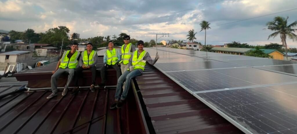 Installers in safety vests fitting solar panels on a rooftop