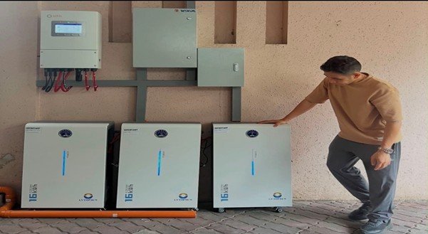 Installer beside three battery storage units below the inverters at a private residence in Mandaue City